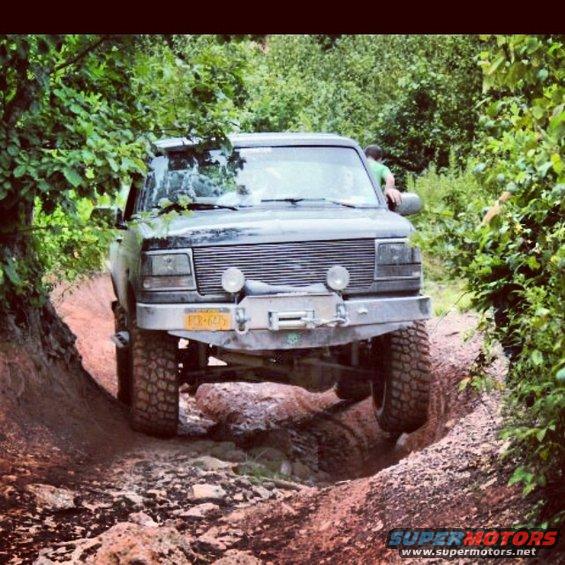 1995 Ford Bronco navigating a steep dirt trail with large tires
