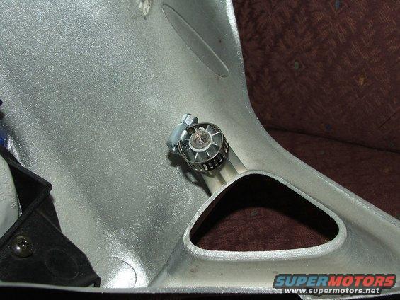 Silver plastic motorcycle fairing with a hose clamp attached to a metal bracket