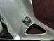 2006 Honda Reflex - A close-up view of a silver plastic motorcycle fairing part with a hose clamp and bracket visible.