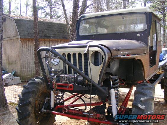 Front view of a modified off-road vehicle with large tires, winch, and custom roll cage