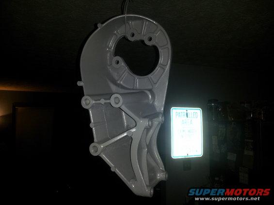 Gray metal bracket hanging, with a reflective sign reading "PATROLLED AREA" to its right