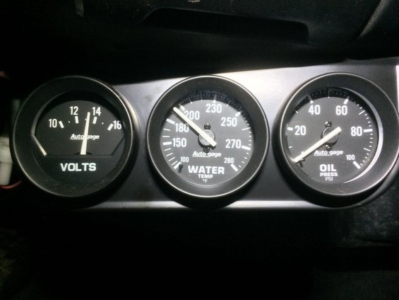 Three Auto Gage brand dashboard gauges: VOLTS, WATER TEMP, and OIL PRESS PSI