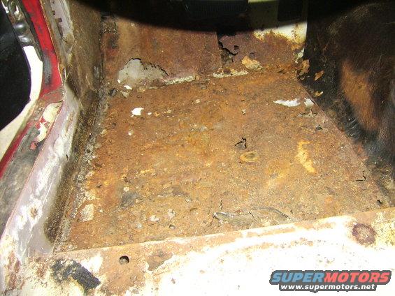 Severely rusted floor pan with holes and corrosion