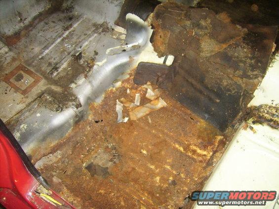 Interior floor rust with visible metal damage and debris