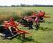 2000 Chevrolet Tahoe - Two agricultural plows are parked on a lawn in front of a field of crops.