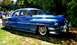 1964 Mercury Monterey - This classic blue sedan features a distinctive chrome grille and whitewall tires, suggesting a mid-20th century model.