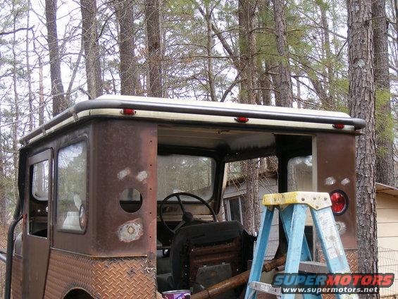 Rusted off-road vehicle with diamond plate rear quarter panels and a roof rack