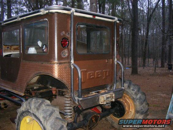 Modified Jeep CJ-5 with large tires and roll cage, seen from the rear