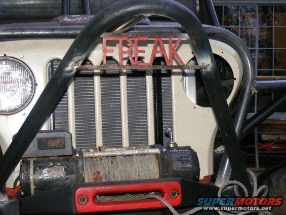 Off-road vehicle front with winch and red "FREAK" lettering on roll cage