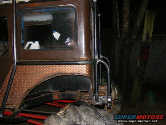 Modified off-road vehicle rear quarter panel with diamond plate fender flare and roll cage tubing