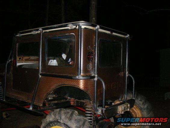 Modified Jeep CJ-5 with custom roll cage and diamond plate fenders, seen from the rear