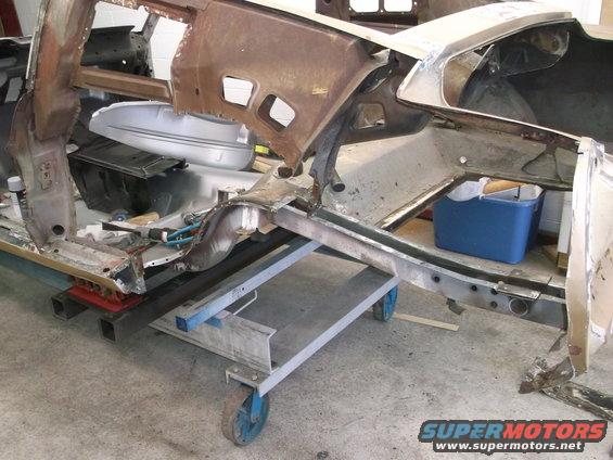 1967 Ford Mustang body shell on a repair dolly, showing frame and inner panels