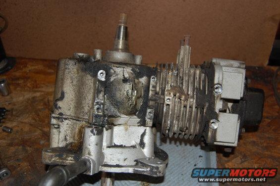 Close-up of a greasy engine gearbox assembly with fins on the side