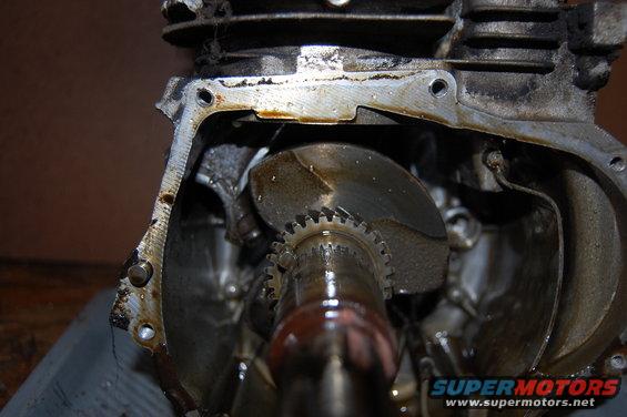 Close-up of engine crankshaft and gears, showing oil residue