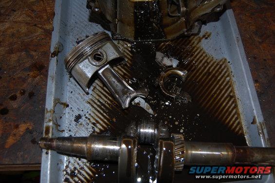Piston and crankshaft from a damaged engine, submerged in oil