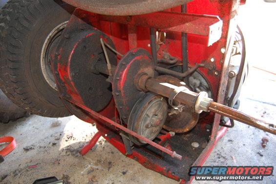 Rear axle and transmission components of a red machine with a large tire