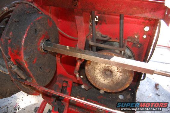 Red machine part with metal shaft and pulley