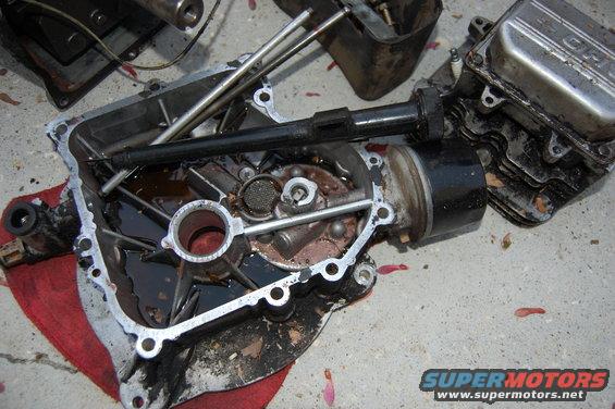 Disassembled engine components on a concrete surface with a red cloth