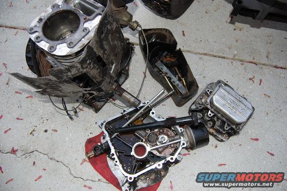 Engine parts disassembled on the ground. One part has 'HONDA' visible