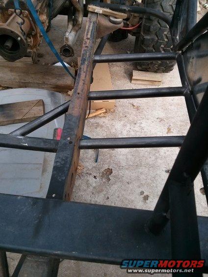 Close-up of a vehicle's frame with engine components and a tire visible