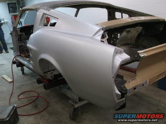 1967 Ford Mustang body shell on restoration stand, rear quarter panel visible