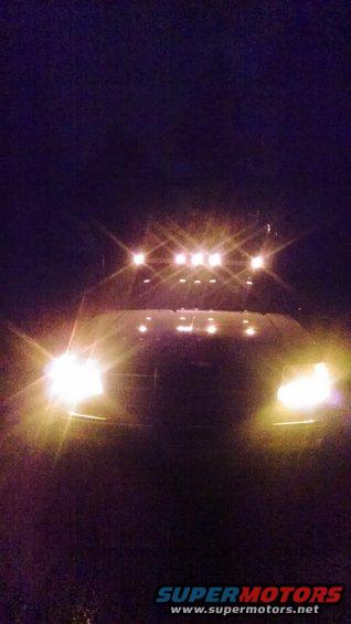 Front view of a truck at night with its headlights and a row of roof-mounted auxiliary lights on
