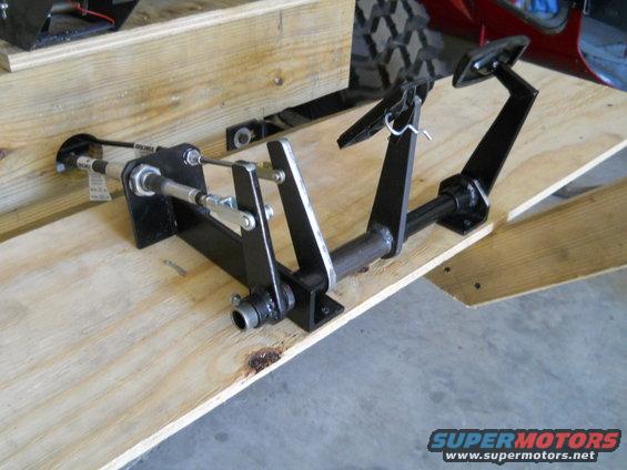 Black metal brake and clutch pedals assembly mounted on wooden planks
