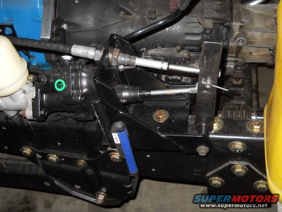 Close-up of vehicle transmission linkage with cables and brackets