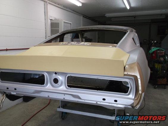 rear of a 1967 Ford Mustang undergoing bodywork, primer applied to trunk lid