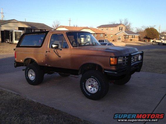 Brown 1994 Ford Bronco with bull bar and lifted suspension
