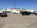 2014 Transnational Firestar 150CC - A black SUV is parked in a lot with several trailers and a commercial building.