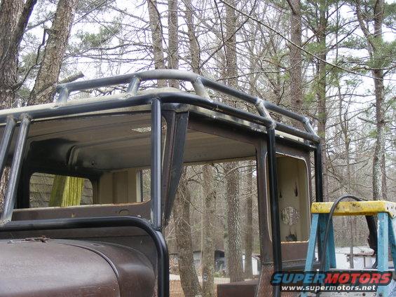 Close-up of a custom roll cage installed on the roof and A-pillars of a vehicle
