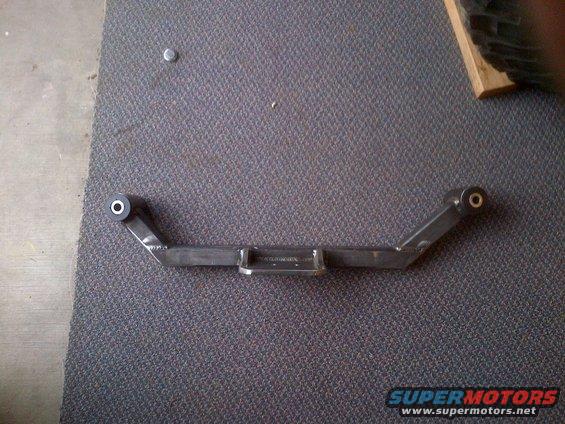 metal suspension component with bushings on ends, sits on carpet