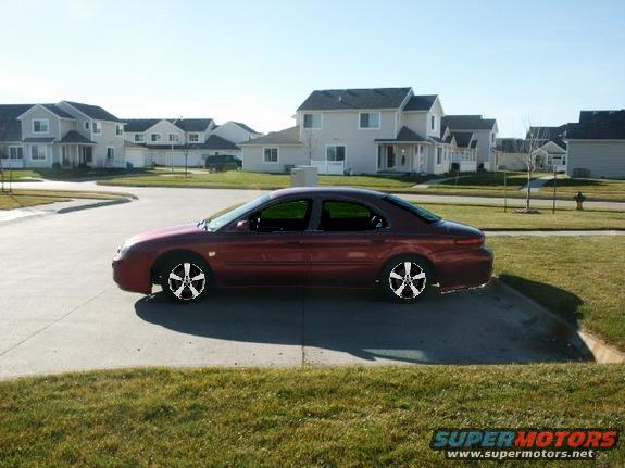 Red 1998 Mercury Sable sedan parked on a suburban street
