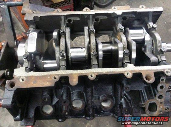 Engine block showing crankshaft and connecting rods. Some parts have numbers stamped on them