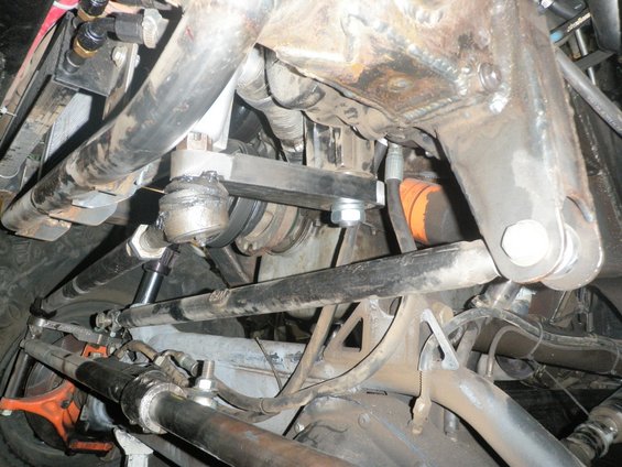 Close-up of vehicle steering linkage, ball joints, and suspension parts
