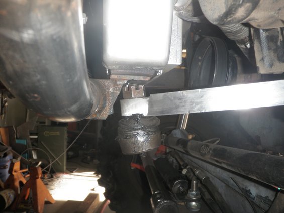 Close-up of steering linkage and suspension components with greased ball joint