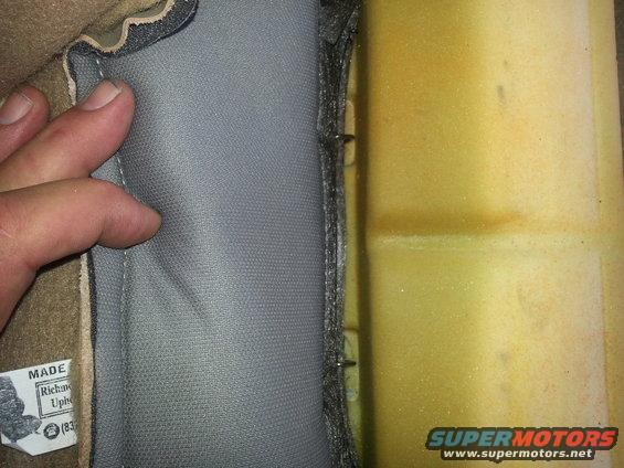 Close-up of car seat foam and gray fabric upholstery with a 'MADE IN Richmond Uph.' label