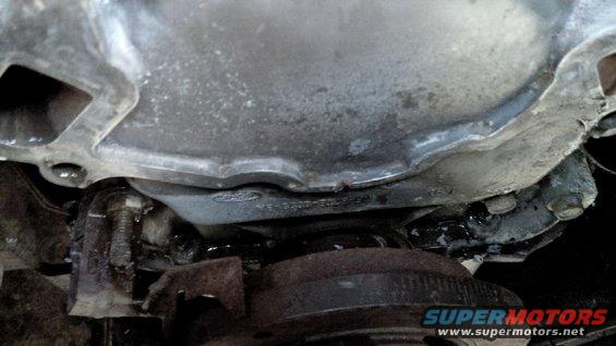 close-up of vehicle's transmission housing with some fluid leaks visible