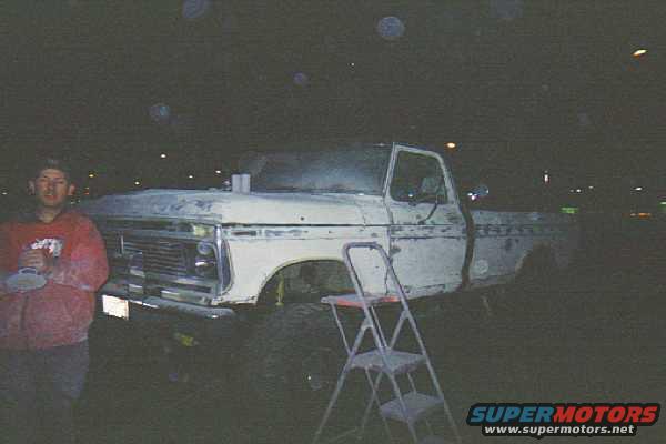 White Ford F-150 truck, primer finish, front 3/4 view, ladder beside it