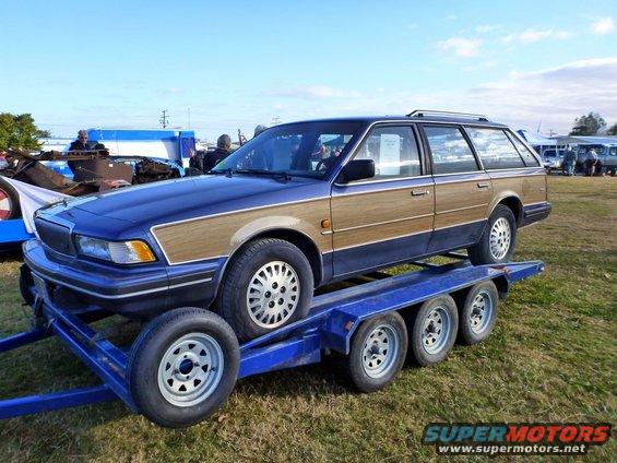 Blue station wagon with wood paneling on a blue trailer