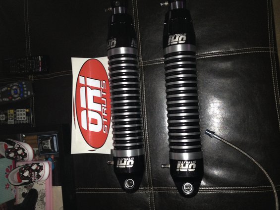 Two black and silver ORI Struts shock absorbers with a red and white ORI Struts sticker