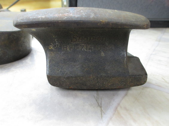 Close-up of a dark metal anvil part with 'Snap-on BF-714 U.S.A.' stamped on its side