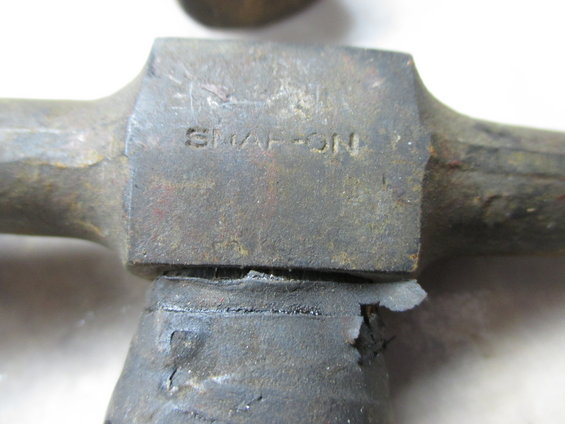 Hammer head with "SNAP-ON" stamped on it, showing wear and damage