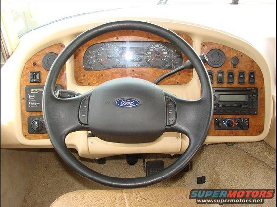 RV dashboard with Ford steering wheel, wood trim, radio, and gauges