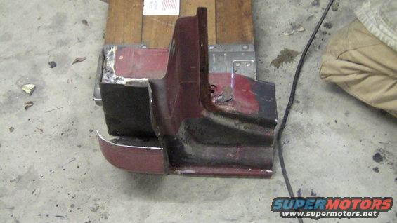 Maroon and black car fender and bumper section with chrome trim, viewed from the side