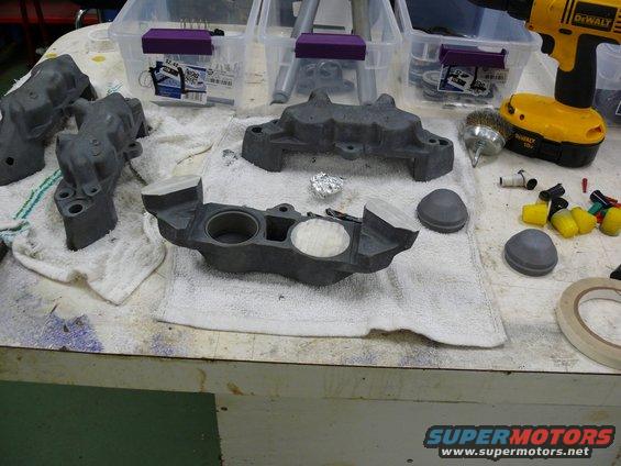 Gray brake calipers and parts on a workbench with tools