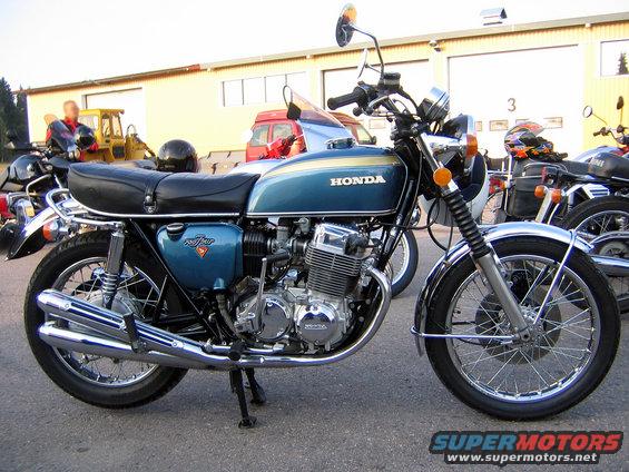 Blue Honda motorcycle with gold stripe and black seat, parked on asphalt