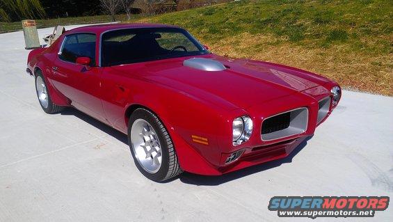 Red Pontiac Firebird with silver shaker hood scoop and aftermarket wheels