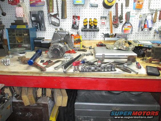 Alternator and assorted tools on a workbench